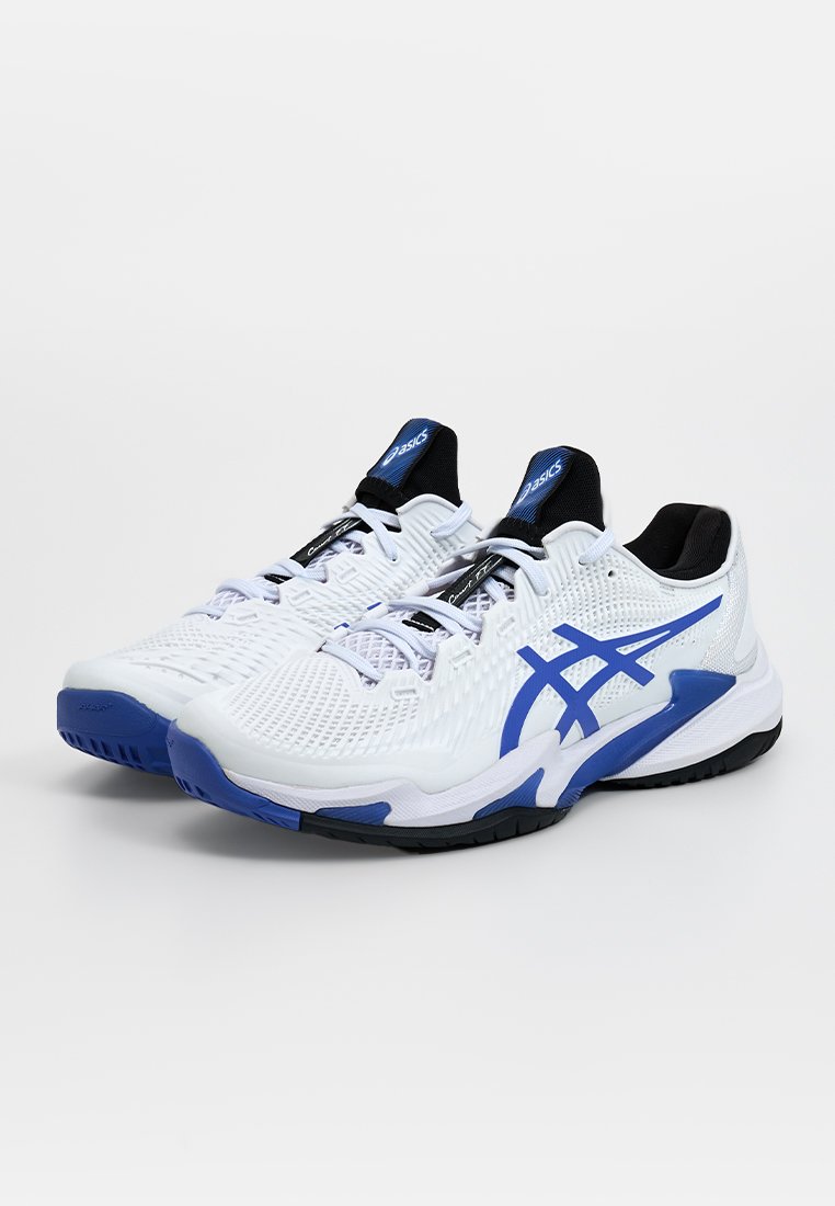 Baskets de sport blanches avec des accents bleus, tige en maille, col rembourré et détails noirs. Elles disposent d'une semelle texturée pour une meilleure adhérence et un bon soutien.