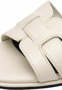 Sandalo bianco in pelle con cinturini larghi, chiusura in Velcro e suola piatta. L'interno è foderato con materiale morbido per il comfort.