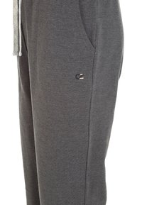 Grå bomullsjoggingbyxor med sidofickor, elastisk midja och dragsko. Har en liten logotyp på sidan nära fickan.