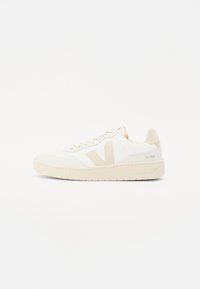 Fehér sneaker bézs kiegészítőkkel, texturált felsőrésszel, kerek orral és vastag gumitalppal. A dizájn ikonikus V logót és márkázást tartalmaz.