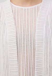 Lichte gebreide top met verticale strepen in het wit en een doorschijnende textuur. Het ontwerp heeft een ronde halslijn en een open voorzijde in cardigan-stijl.