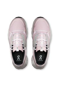 Baskets de sport rose clair avec une tige en maille, des accents argentés réfléchissants et une semelle rembourrée. Présentent un intérieur et un logo noirs contrastants.