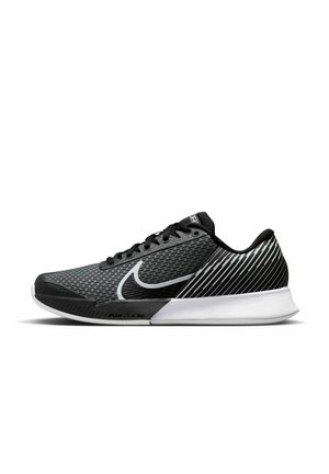 Baskets de sport noires et grises avec une tige en mesh, présentant un grand logo swoosh blanc de Nike et des accents rayés sur le talon. Semelle intermédiaire en mousse.