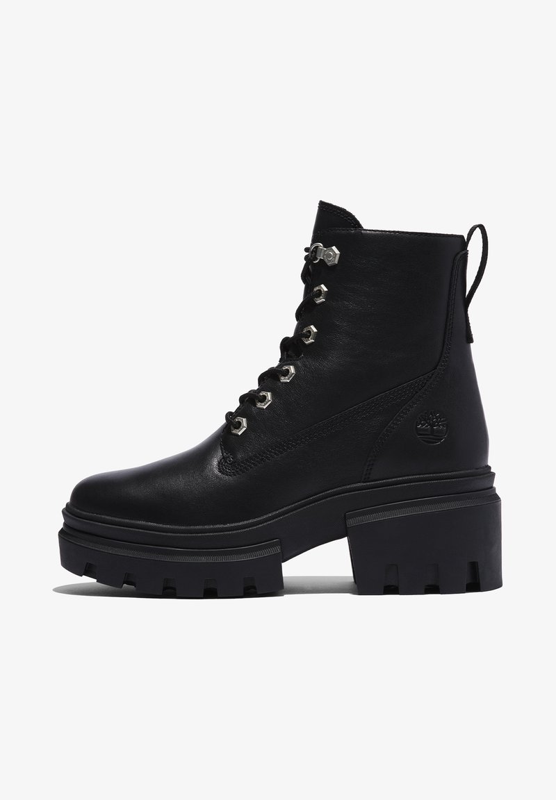 Bottines noires en cuir avec une semelle épaisse, bout arrondi et accessoires en métal argenté sur les lacets. Elles comprennent une languette à l'arrière et un logo embossé.