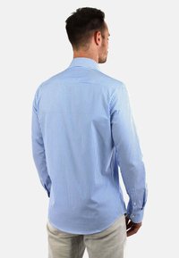 Gestreept herenoverhemd in lichtblauw en wit, met een button-down kraag en lange mouwen met manchetknopen, gemaakt van een soepele stof.