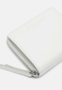 Biała skórzana portmonetka o teksturowanej powierzchni, z zamknięciem na zamek, srebrnym okuciem i wytłoczonym logo marki na przedniej stronie. Kompaktowy, prostokątny kształt.