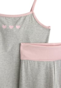 Szary top bez rękawów z różowym obszyciem, ozdobiony trzema małymi różowymi serduszkami nadrukowanymi na tkaninie. Miękka faktura, prosty design.