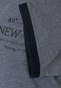 Męska koszulka polo w ciemnoszarym kolorze, wykonana z tkaniny o fakturze, z czarnym prążkowanym kołnierzykiem i haftowanym tekstem w kontrastowym kolorze.