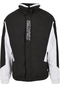 Chaqueta negra y blanca con cremallera, alto cuello, puños elásticos, bolsillos laterales y logo "STARTER" en la parte frontal. Presenta un diseño deportivo.