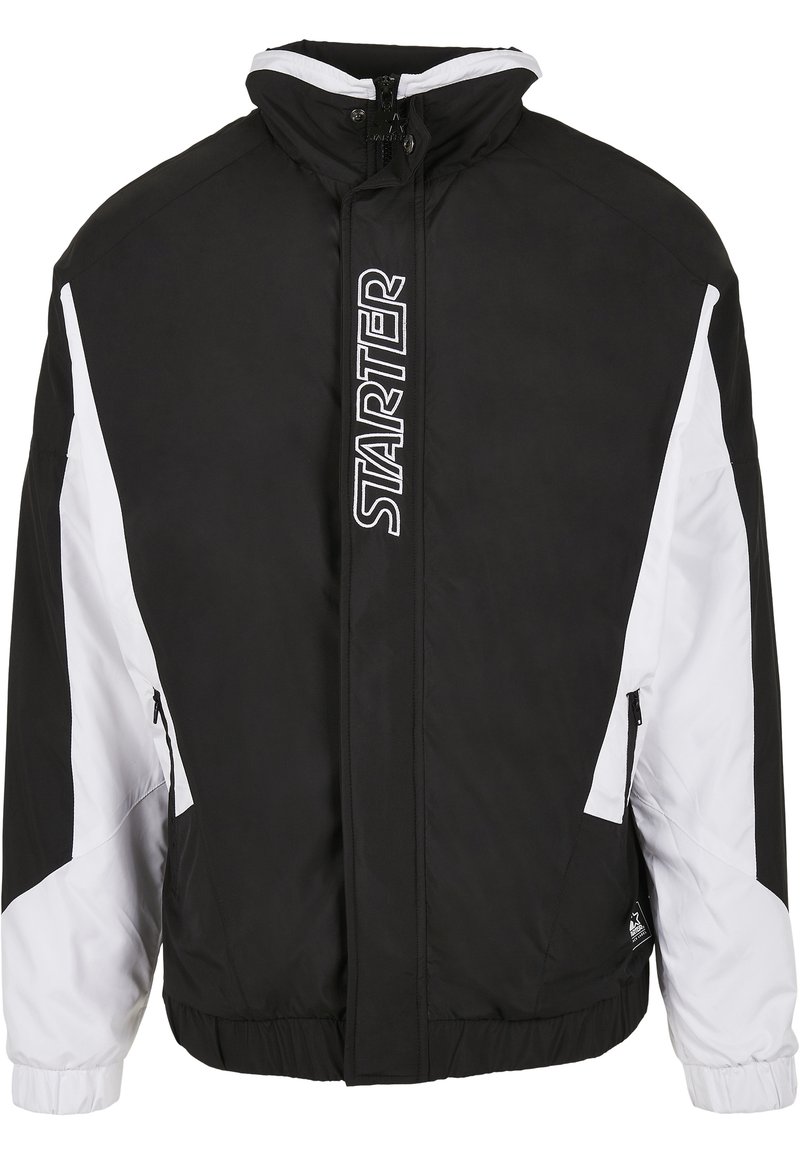 Chaqueta negra y blanca con cremallera, alto cuello, puños elásticos, bolsillos laterales y logo "STARTER" en la parte frontal. Presenta un diseño deportivo.