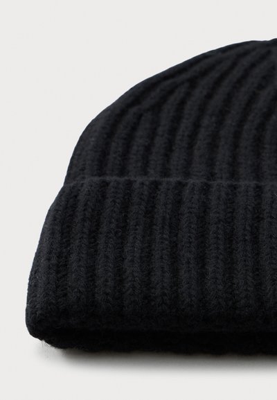 Musthave musta sooniku müts, millel on volditud serv, valgel taustal.