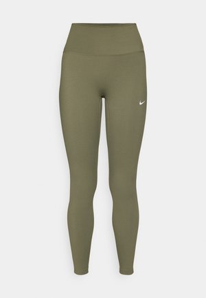 Leggings vert olive avec une taille haute, fabriqués à partir d'un matériau lisse et extensible, présentant un petit logo blanc près de la taille.