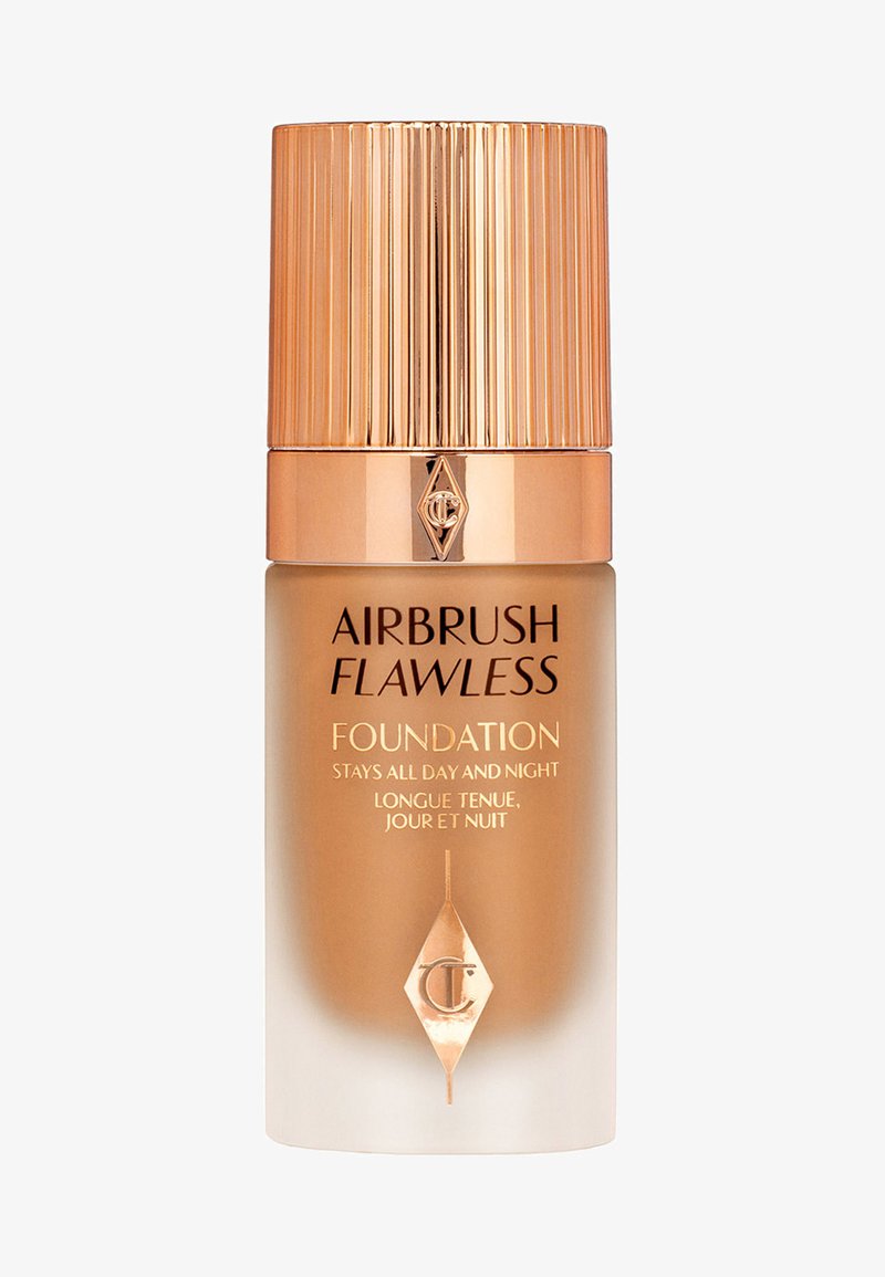 Airbrush Flawless foundation in a glass bottle, featuring a ribbed metallic gold cap and a gradient brown to beige body with black lettering.
