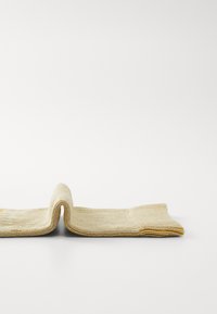 Woven beige textile with a textured surface. The ends are folded with a yellow accent at the edges, creating a soft, flexible shape.