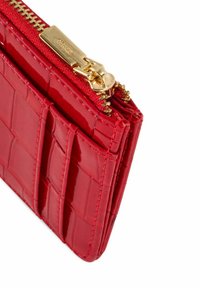 Czerwony portfel z lakierowanej skóry z teksturą krokodyla, zamek błyskawiczny i złote okucia. Posiada przegrody na karty po boku.