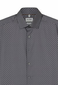 Button-up shirt featuring a dark navy background with a geometric pattern of small light-colored circles. Short collar, body fit design.
