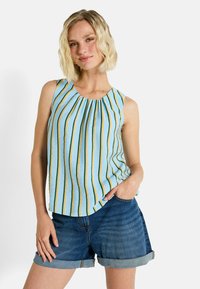 Top sin mangas azul con rayas verticales amarillas y verdes, con un escote plisado. Combinado con pantalones cortos de mezclilla.