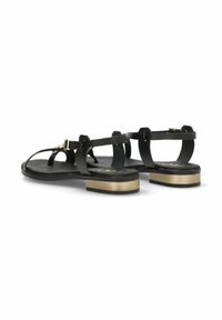 Las sandalias planas negras presentan tiras delgadas, un acento metálico dorado en el talón y una plantilla texturizada y oscura para mayor comodidad.