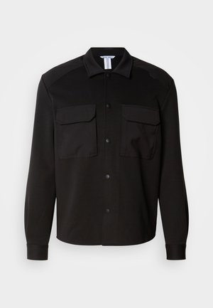 Black shirt jacket made of a smooth, lightweight fabric. Features two chest pockets, button closures, and pointed collar. Long sleeves with cuffs.