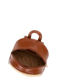 Mochila de cuero marrón con forma redondeada, cierre de cremallera y textura trenzada en la base. El interior está forrado con un patrón de logo.
