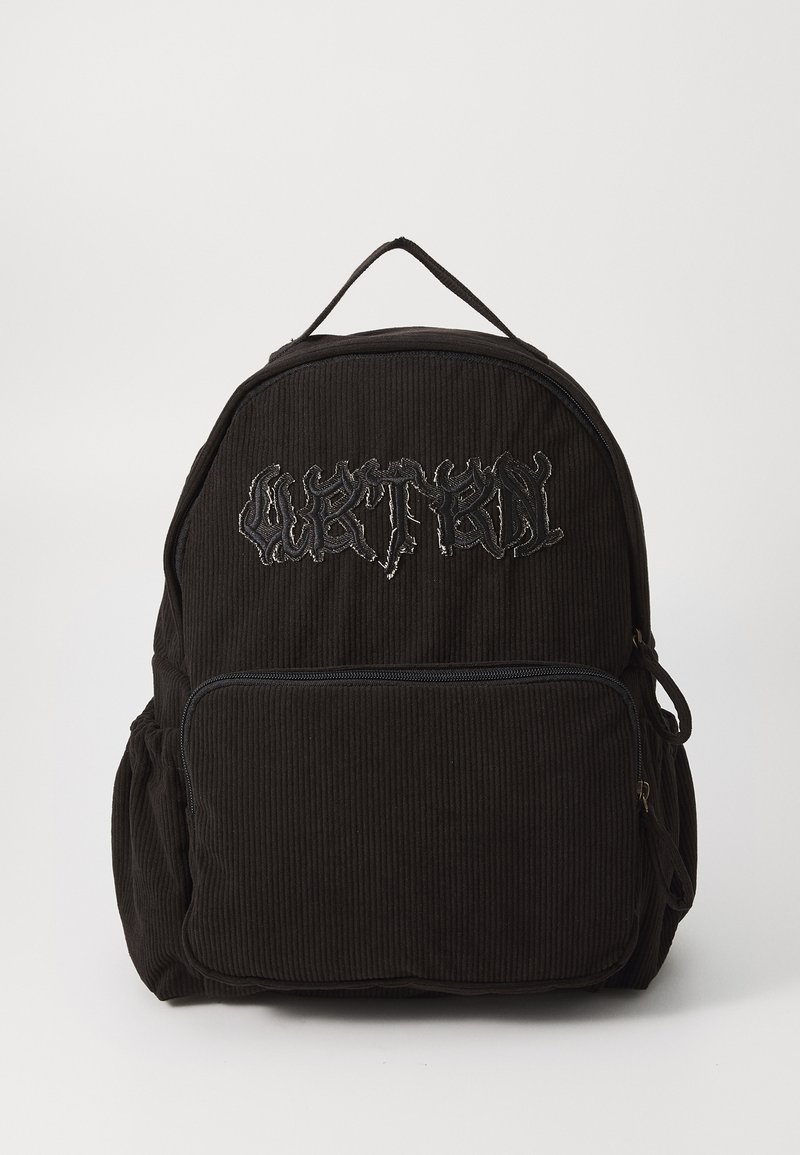 Svart kordfläskeryggsäck med broderad logotyp, ett huvudfack, ficka med blixtlås fram, sidofickor och ett handtag ovanpå. Strukturerad yta.