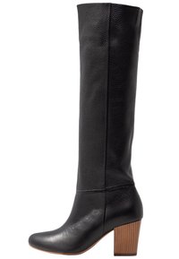 Bottes noires en cuir hautes avec une finition texturée, bout rond et un talon épais avec des bandes en bois verticales.
