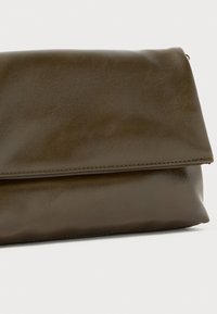 Oliivroheline kunstnahast klambri kott, millel on volditud klapp, sile tekstuur ja korralik õmblus ääres.
