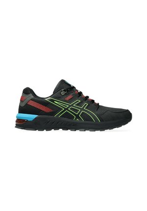 Chaussures de sport noires avec des accents verts, des détails rouges et un talon bleu. Présentent un revêtement texturé et une semelle extérieure en caoutchouc robuste.