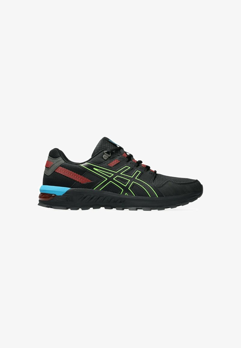 Chaussures de sport noires avec des accents verts, des détails rouges et un talon bleu. Présentent un revêtement texturé et une semelle extérieure en caoutchouc robuste.