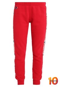 Rode katoen trainingsbroek met een taps toelopende pasvorm, voorzien van zijlogo-strepen en geribbelde manchetten. Inclusief een label met de merknaam op de tailleband.