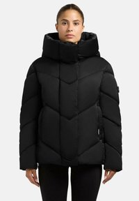Schwarze Daunenjacke mit hohem Kragen, ausgestattet mit einem Zickzack-quilteten Muster, dicker Polsterung und langen Ärmeln. Leicht und mit weichem Textur.