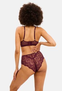 Burgundy spetsbehå och matchande högmidjade trosor. Behån har justerbara band och en hakförslutning, med vågiga spetskanter.