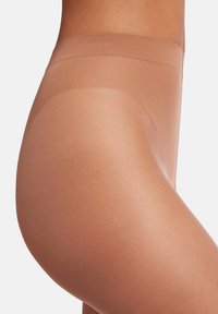 Hudfärgad kontrolltoppstrumpbyxor med en mjuk textur och sömnlös design. Midjebandet är brett och ger en säker passform utan att skava.