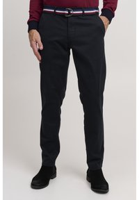 Navy chinos with a slim fit, made from lightweight fabric. Paired with a multicolored striped belt and black ankle boots.