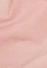 Měkká růžová tkanina s jemnými záhyby a jemným texturovaným vzorem.