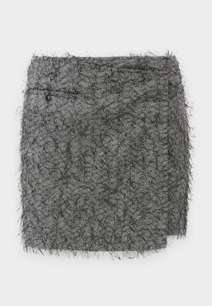 Textured black and white houndstooth mini skirt with frayed edges, featuring a side pocket with a button. Made of wool blend material.