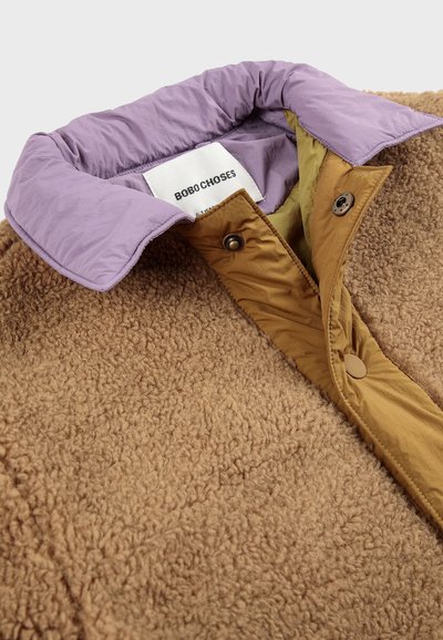Tans fleecejacke mit einem lavendelfarbenen Kragen und einer braunen Druckknopfleiste. Verfügt �über eine weiche Textur und ein Markenlabel im Kragen.
