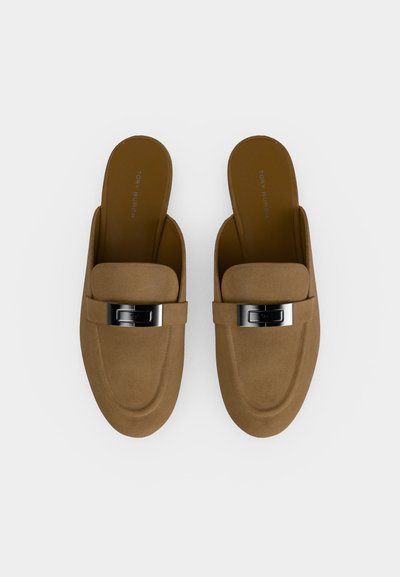 Paire de mocassins en cuir marron à enfiler avec boucles en métal noir, semelles plates et marquage "Tory Burch" à l’intérieur.