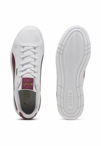 Adidași albi cu un finisaj din piele texturată, accente burgund pe laterale și o talpă din cauciuc cu un model în diamant.