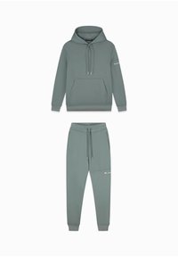 Lichtgroene hoodie en joggingset van zachte stof. De hoodie heeft een kangoeroezak en een trekkoord bij de capuchon; de joggers hebben een elastische boord.