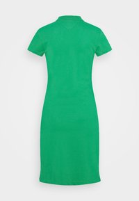 Vihreä lyhythiha polo-mekko, joka on valmistettu sileästä kankaasta. Mekossa on klassinen kaulus, vartalonmyötäinen muoto ja polven mittainen helma. Ei näkyviä kuvioita tai yksityiskohtia.