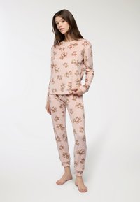 Set di pigiama rosa chiaro composto da una maglia a maniche lunghe e pantaloni, decorato con un motivo floreale marrone. Tessuto morbido con una vestibilità comoda.