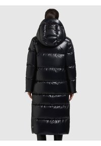 Lång, puffig svart jacka med glansig yta, utrustad med huva och horisontellt quiltat mönster, som sträcker sig till mitten av vaden, tillverkad av isolerande material.