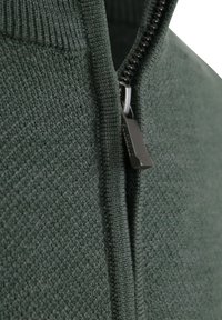 Groene trui met ritssluiting, voorzien van een gestructureerd breipatroon, een soepele ritsrand en geribbelde manchetten, met de nadruk op een gestructureerd ontwerp.