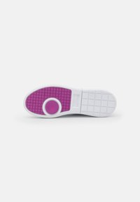 Sohle eines Sneakers mit weißem Grund, strukturiertem Griffmuster und einem lila Akzent in kreisförmiger Form in der Mitte.
