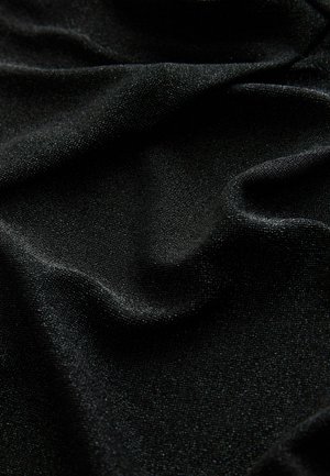 Fekete textil sima felülettel és finom fényességgel, amelyet lágy redők és gyűrődések díszítenek, fokozva dinamikus megjelenését.