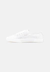 Baskets en toile blanche avec une surface texturée, bout rond, semelle plate et œillets en métal. Présentent un détail de logo subtil sur le côté.