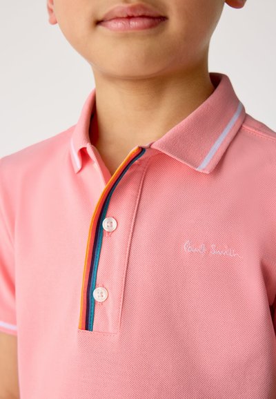Roze poloshirt met een gestructureerde stof, voorzien van een drieknopenbies en contrasterende strepen in geel, blauw en oranje bij de kraag.