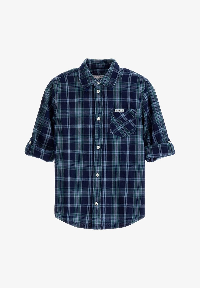 Chemise à carreaux bleu marine et verte avec manches repliées et une poche poitrine étiquetée "GUESS".