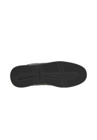 Suela de zapatilla negra con una superficie texturada y patrón, y un diseño de banda de rodadura prominente. Presenta un estampado de marca y un acabado suave alrededor de los bordes.